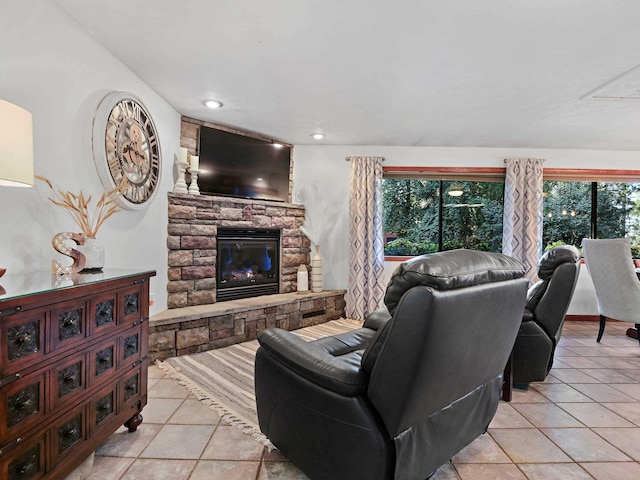 tiled living room with recessed lighting and a stone fireplace