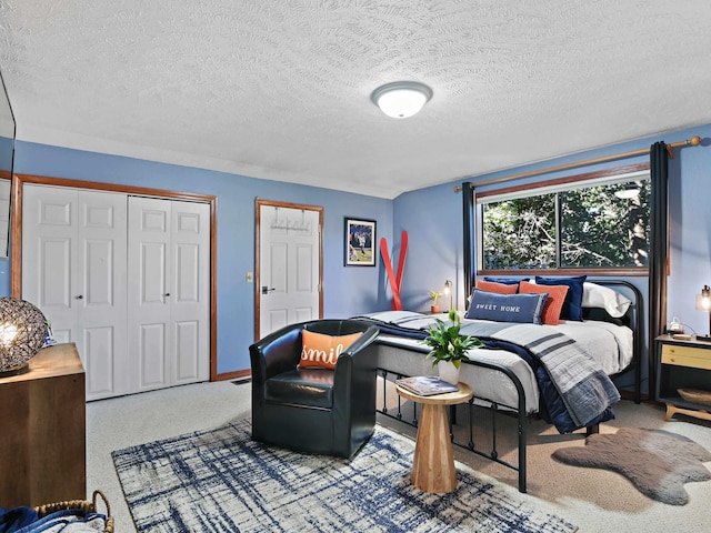 carpeted bedroom with baseboards and a textured ceiling