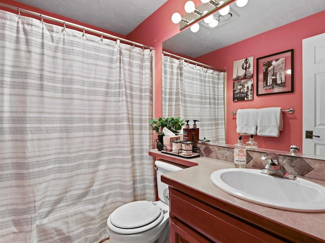 bathroom featuring vanity, toilet, and a textured ceiling