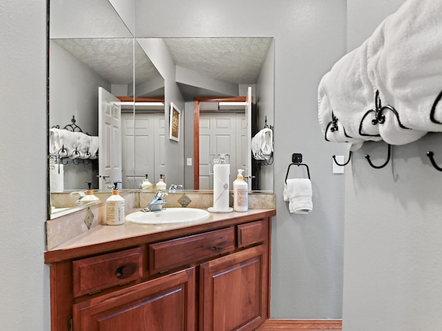bathroom featuring vanity, a textured ceiling, and wood finished floors