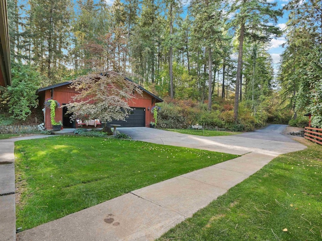 view of front facade with concrete driveway, an attached garage, and a front yard