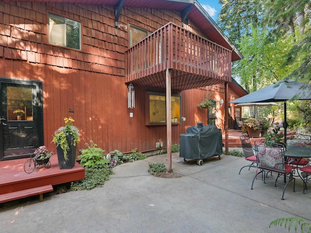 view of patio featuring outdoor dining area, a balcony, a deck, and a grill