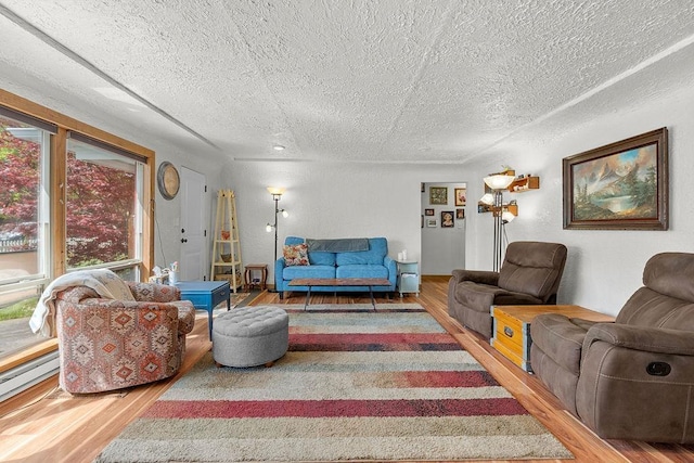 living area with a textured ceiling, wood finished floors, and a baseboard radiator