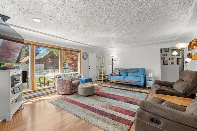 living room with a textured ceiling, a healthy amount of sunlight, and wood finished floors