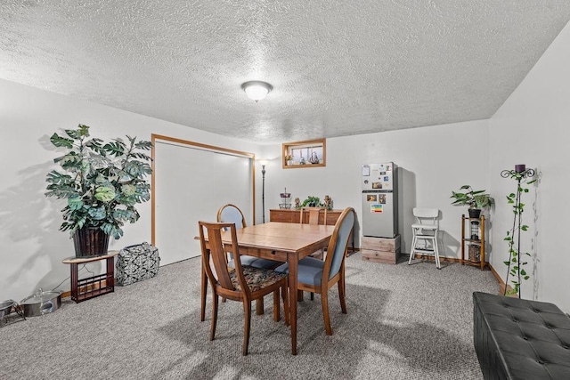 dining room featuring carpet flooring and a textured ceiling