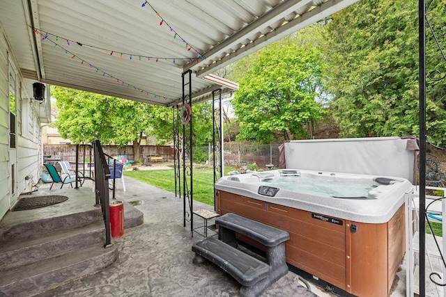 view of patio / terrace with a fenced backyard and a hot tub