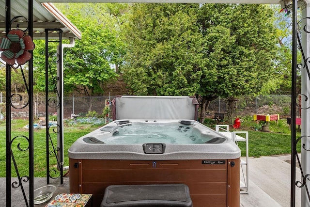 view of patio featuring a hot tub and fence