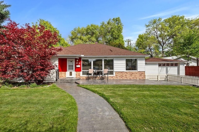 view of front of house featuring brick siding, a garage, fence, and a front yard