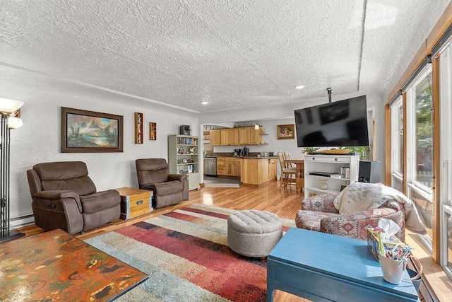 living room with light wood-type flooring, recessed lighting, and a textured ceiling
