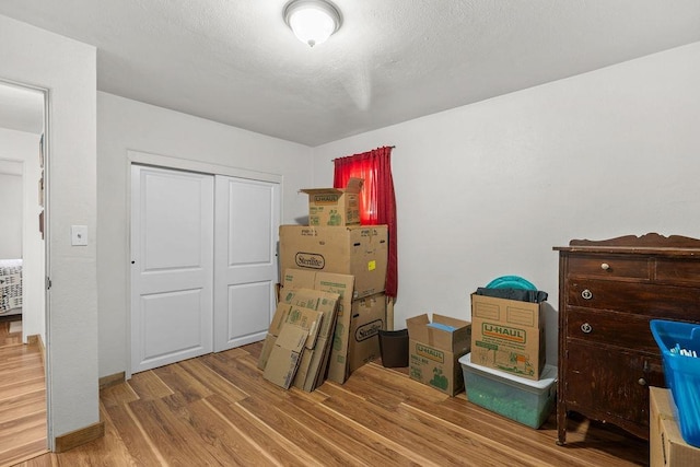 bedroom with wood finished floors and a closet