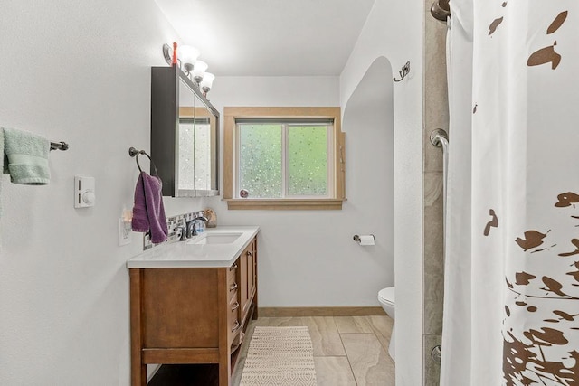 bathroom featuring vanity, marble finish floor, toilet, baseboards, and a shower with shower curtain