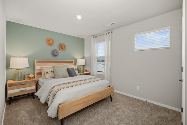 carpeted bedroom featuring baseboards and visible vents
