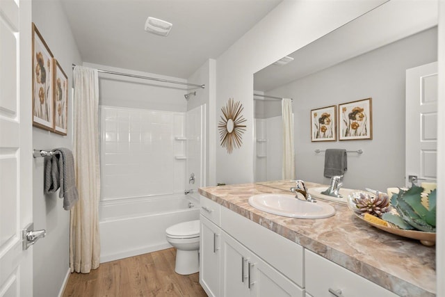 full bathroom with vanity, visible vents, wood finished floors, toilet, and shower / bath combo