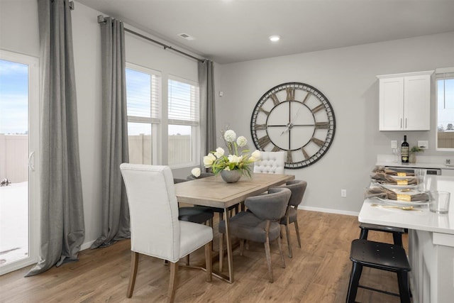 dining space featuring light wood-type flooring, baseboards, and visible vents