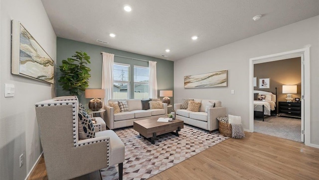 living area featuring visible vents, recessed lighting, baseboards, and wood finished floors