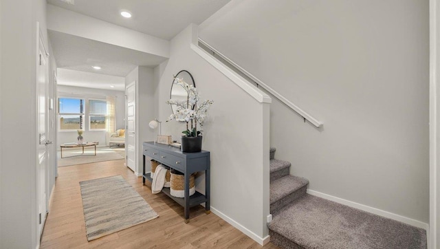staircase featuring recessed lighting, baseboards, and wood finished floors