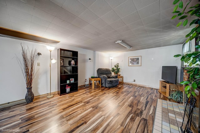 sitting room with baseboards and wood finished floors