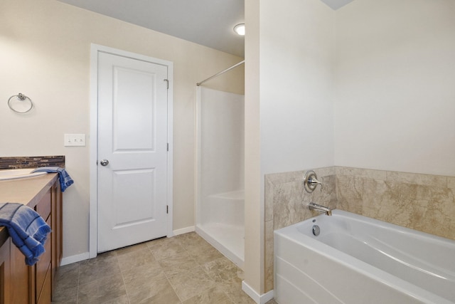 bathroom featuring a garden tub, baseboards, walk in shower, and vanity