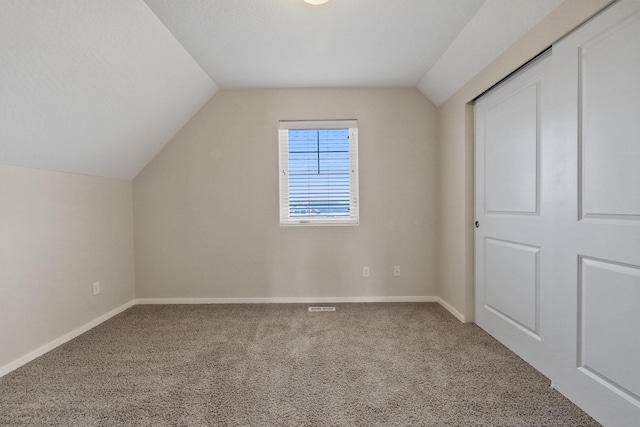 bonus room with baseboards, vaulted ceiling, carpet flooring, and visible vents