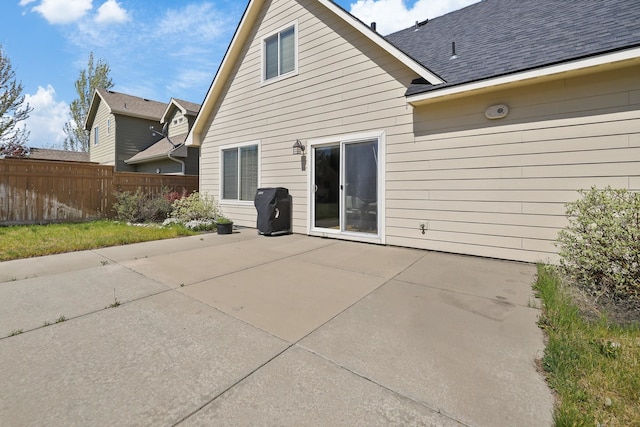 back of property with fence and a patio area
