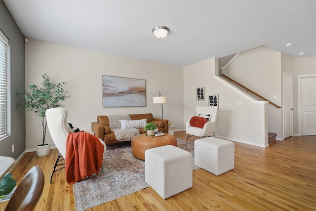 living area with stairway, baseboards, and wood finished floors