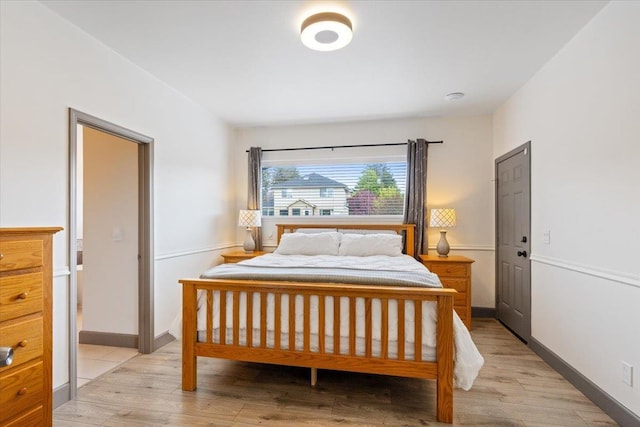 bedroom featuring baseboards and light wood-style flooring