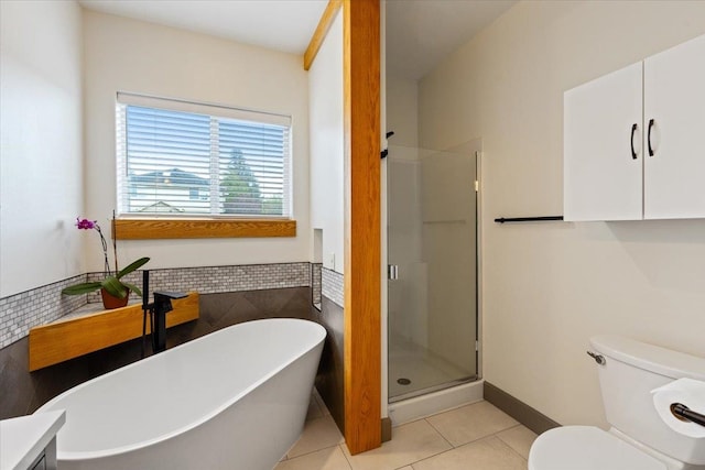 bathroom featuring tile patterned flooring, wainscoting, tile walls, a soaking tub, and a stall shower