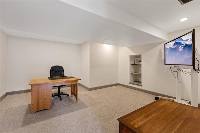 carpeted home office with built in features and baseboards