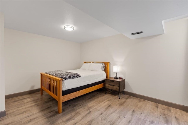 bedroom featuring baseboards, visible vents, and light wood finished floors