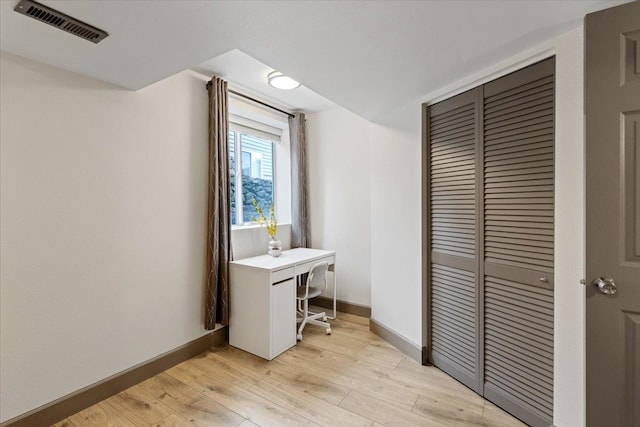 office featuring baseboards, light wood-type flooring, and visible vents