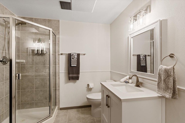bathroom featuring vanity, a wainscoted wall, a shower stall, and visible vents