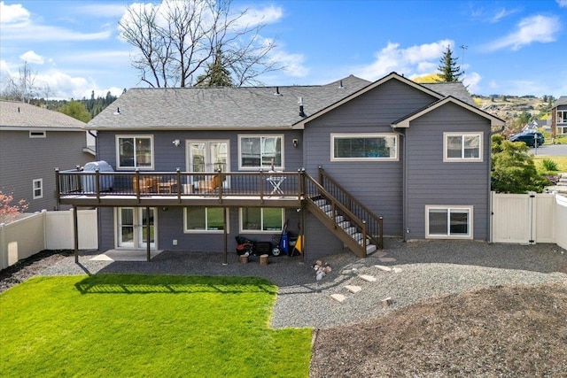 rear view of property with a wooden deck, a fenced backyard, stairs, a gate, and a lawn