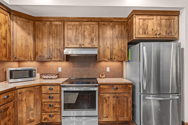 5034 Bittrich Antler Rd, Deer Park, WA 99006 - kitchen with decorative backsplash, ventilation hood, brown cabinetry, and stainless steel appliances