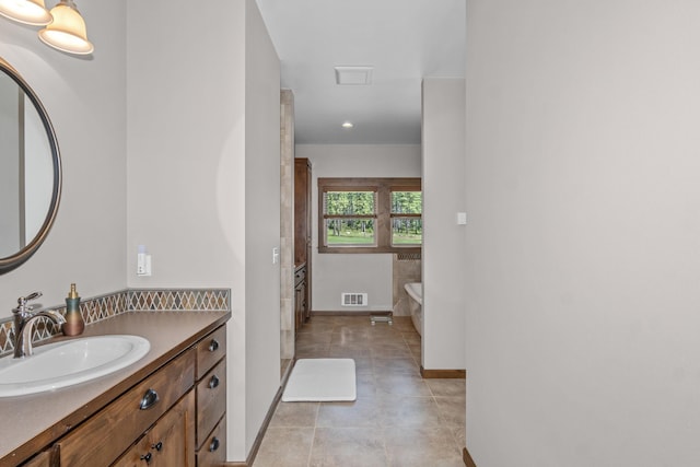 5034 Bittrich Antler Rd, Deer Park, WA 99006 - full bathroom with visible vents, a freestanding bath, vanity, baseboards, and tile patterned floors
