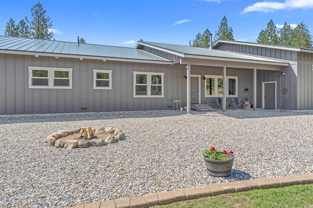 5034 Bittrich Antler Rd, Deer Park, WA 99006 - rear view of property with board and batten siding, a fire pit, and metal roof
