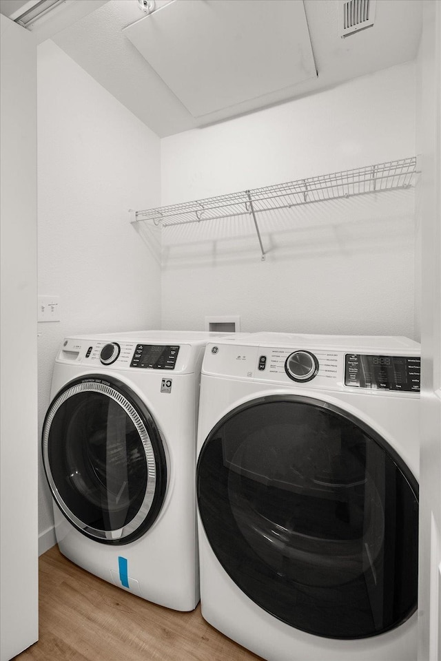 laundry room with laundry area, light wood-style flooring, independent washer and dryer, and visible vents