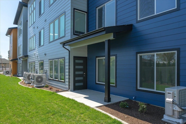 back of property with a lawn, ac unit, and a patio area