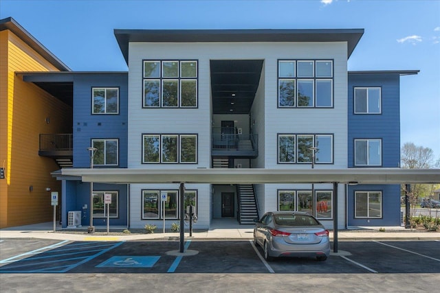 exterior space featuring covered parking, stairs, and cooling unit