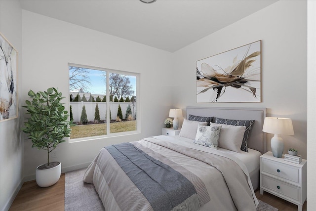 bedroom with baseboards and wood finished floors