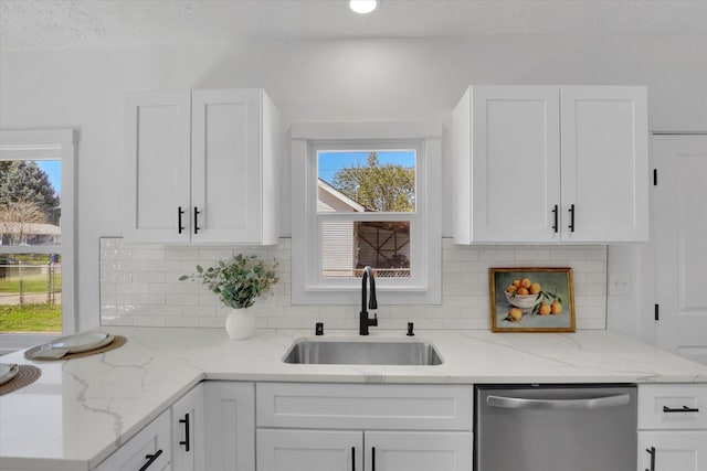3903 E Hartson Ave, Spokane, WA 99202 - kitchen with stainless steel dishwasher, white cabinetry, decorative backsplash, and plenty of natural light