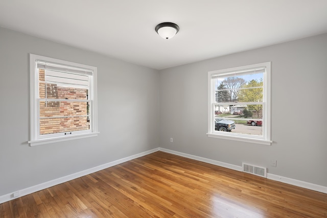 spare room with baseboards, visible vents, and light wood-type flooring