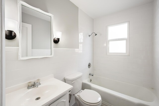 full bathroom with toilet, shower / bath combination, tile walls, and vanity