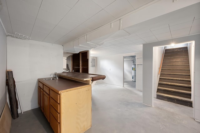 finished below grade area featuring a sink, strapped water heater, stairway, and electric panel