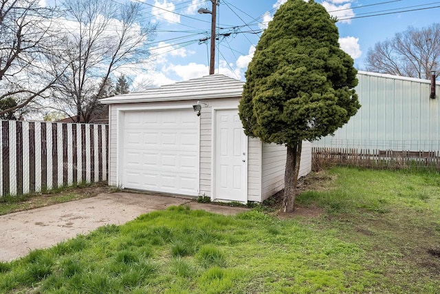 garage featuring fence and driveway