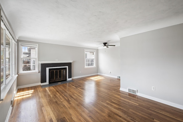 unfurnished living room with visible vents, ceiling fan, wood finished floors, and a healthy amount of sunlight