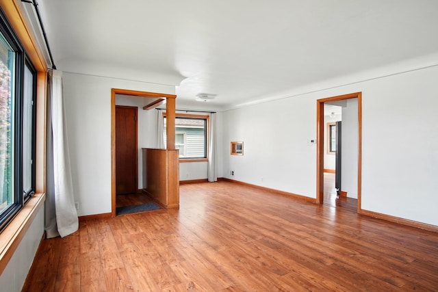 unfurnished room with baseboards and light wood-style flooring