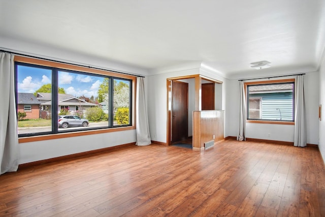 interior space featuring wood-type flooring, baseboards, and visible vents