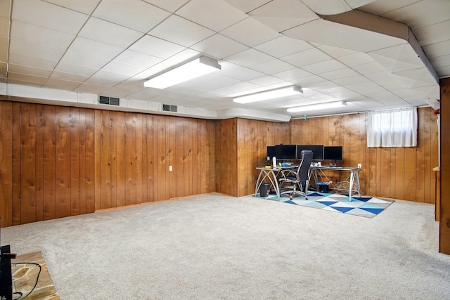 carpeted home office with visible vents and wood walls
