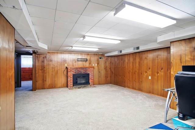 interior space featuring wooden walls, carpet floors, a fireplace, and visible vents