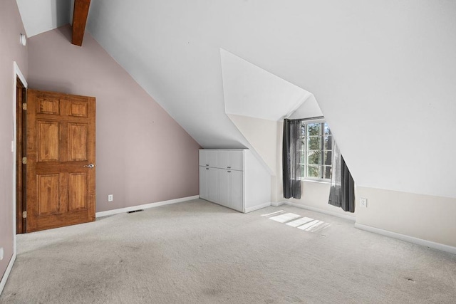 additional living space featuring baseboards, lofted ceiling with beams, carpet flooring, and visible vents